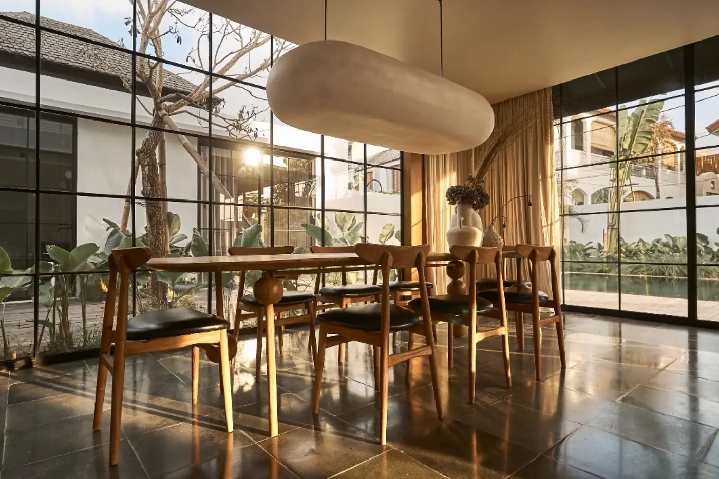 Dining area with a sculptural pendant beside the Umalas pool