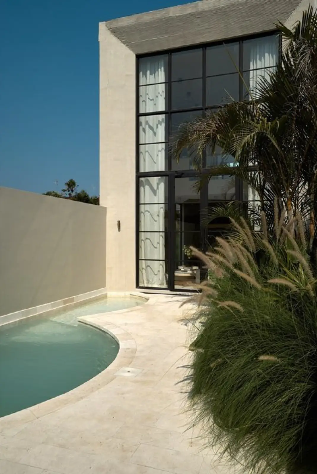 Pool terrace and rendered facade at the Vesna townhouse complex in Berawa